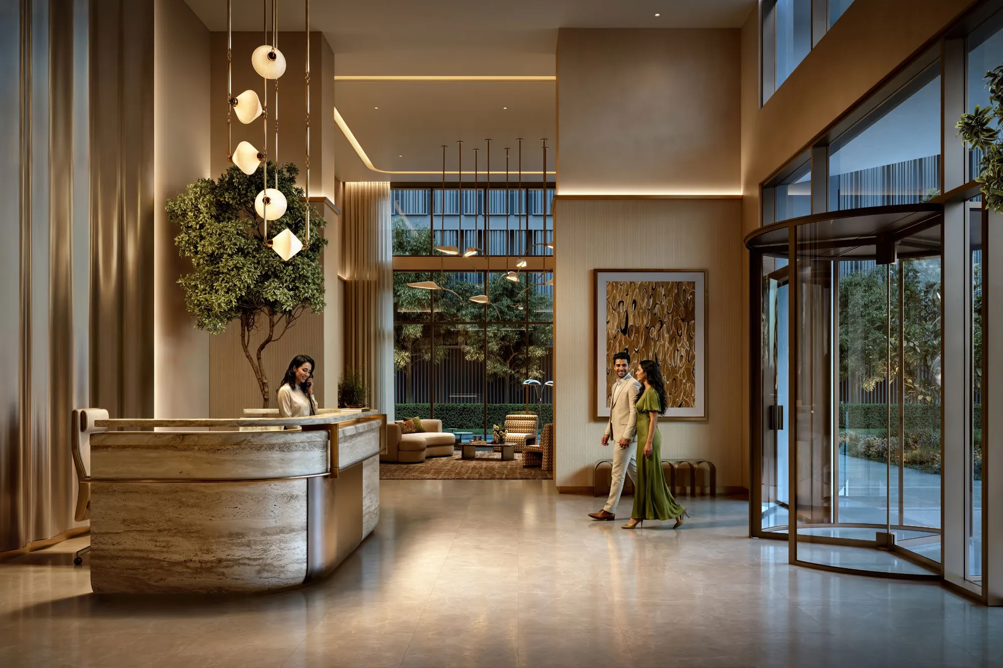 Lobby with travertine reception desk, pendant lights, indoor tree and revolving door