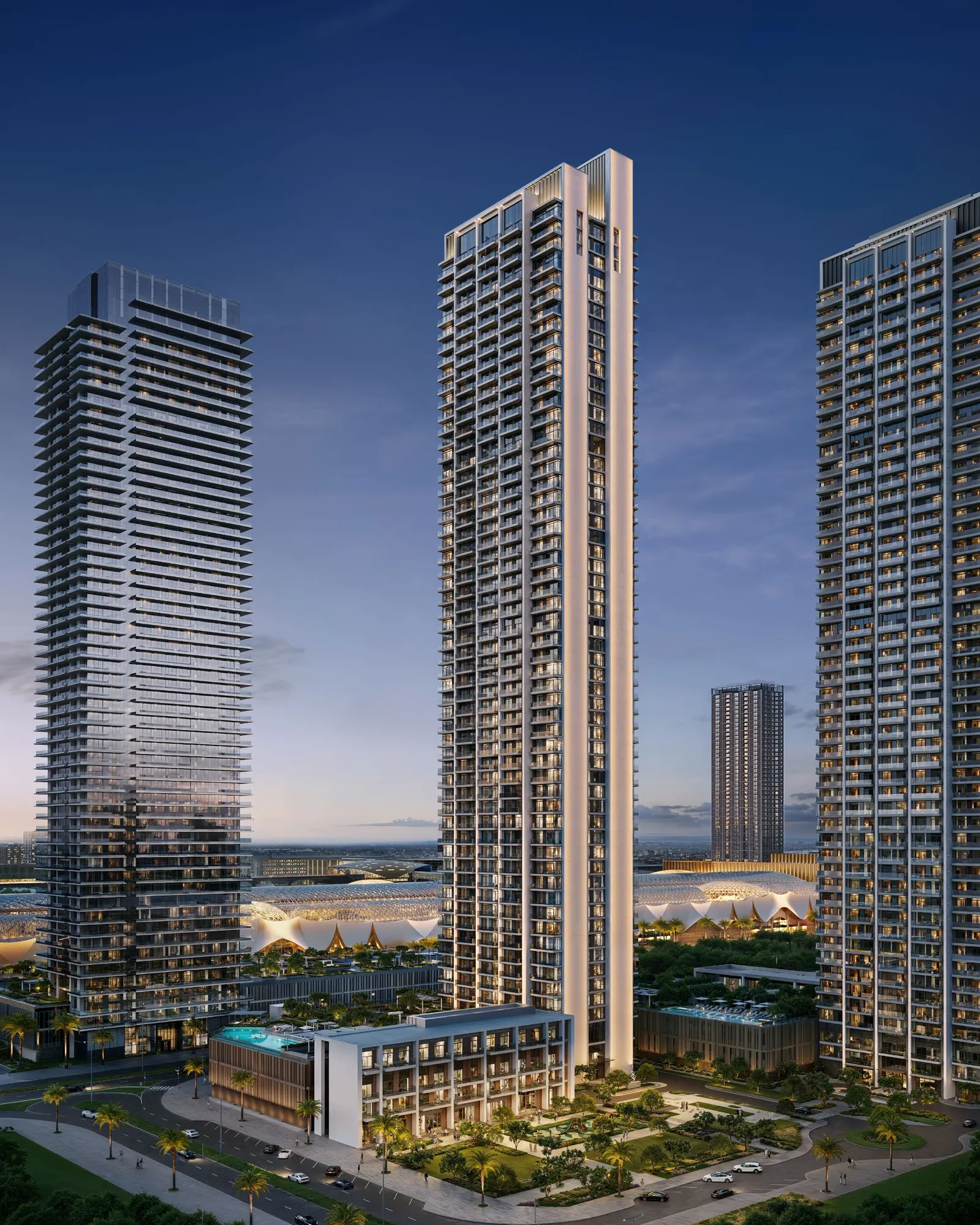 Valia's tall slender tower at dusk above its landscaped podium and pools